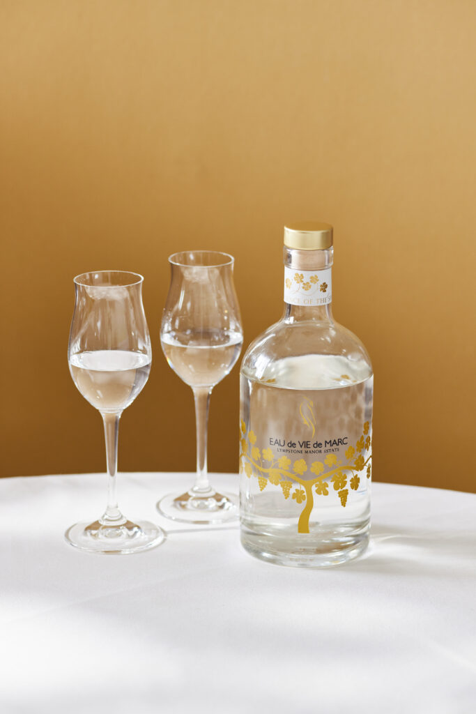 Bottle of Lympstone Manor Eau De Vie with two glasses for serving.